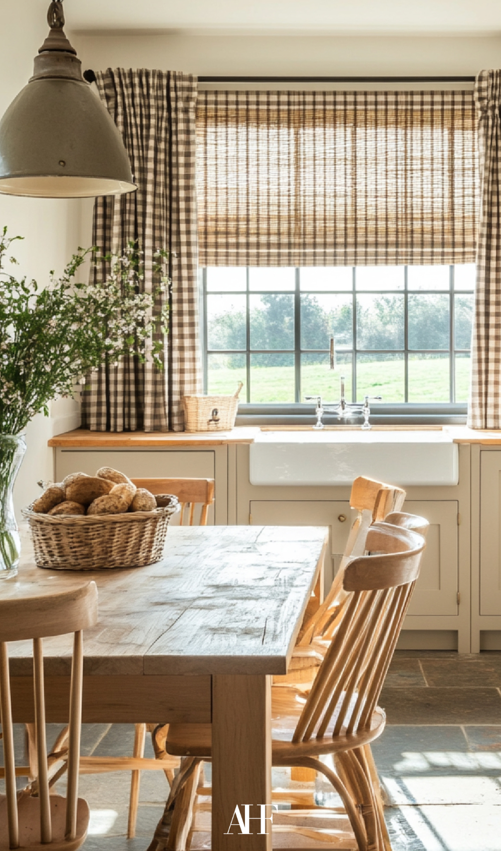 Beautiful farmhouse summer window treatments in a kitchen. A wooden dining table with wooden dining chairs.