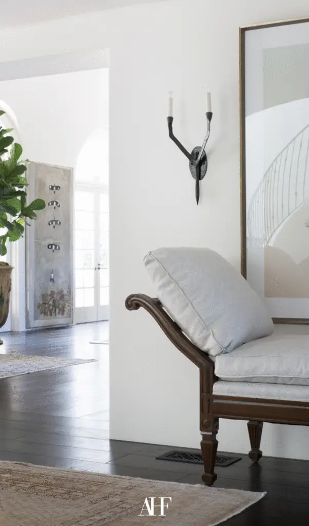 A modern traditional home with a closeup picture of a bench with pillows, the hallway in the background.