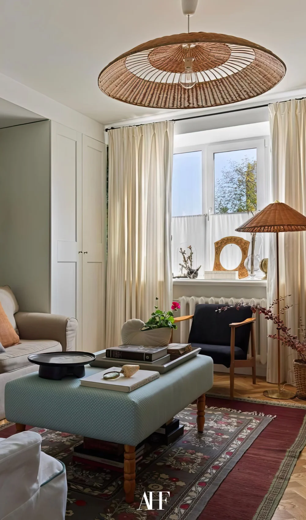 A colorful small apartment living room with mid century modern decor pieces. A window.