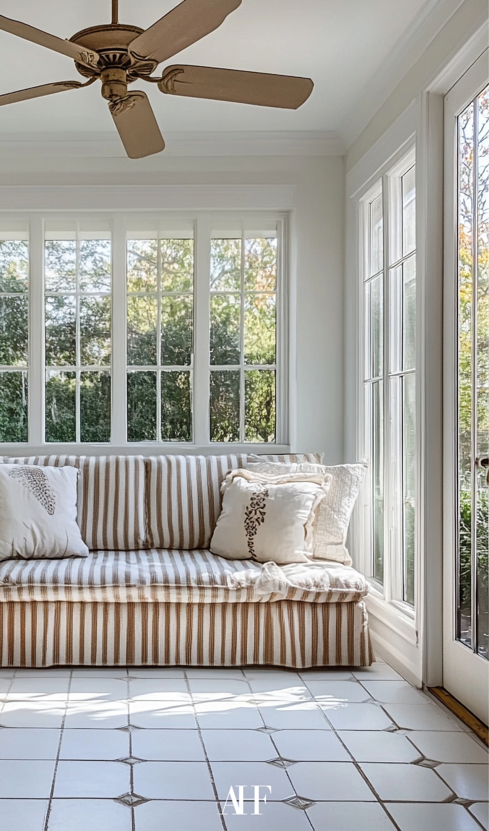 Linen Loveseat in a Soft Neutral Shade with stripes, a sunroom with lots of sunlight and large windows.