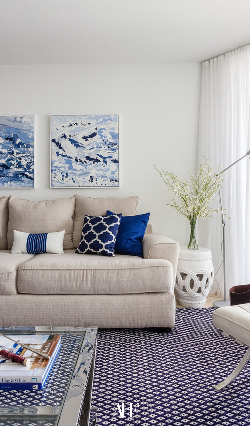 A bright and airy living room with a beige sofa and dark blue pillows.