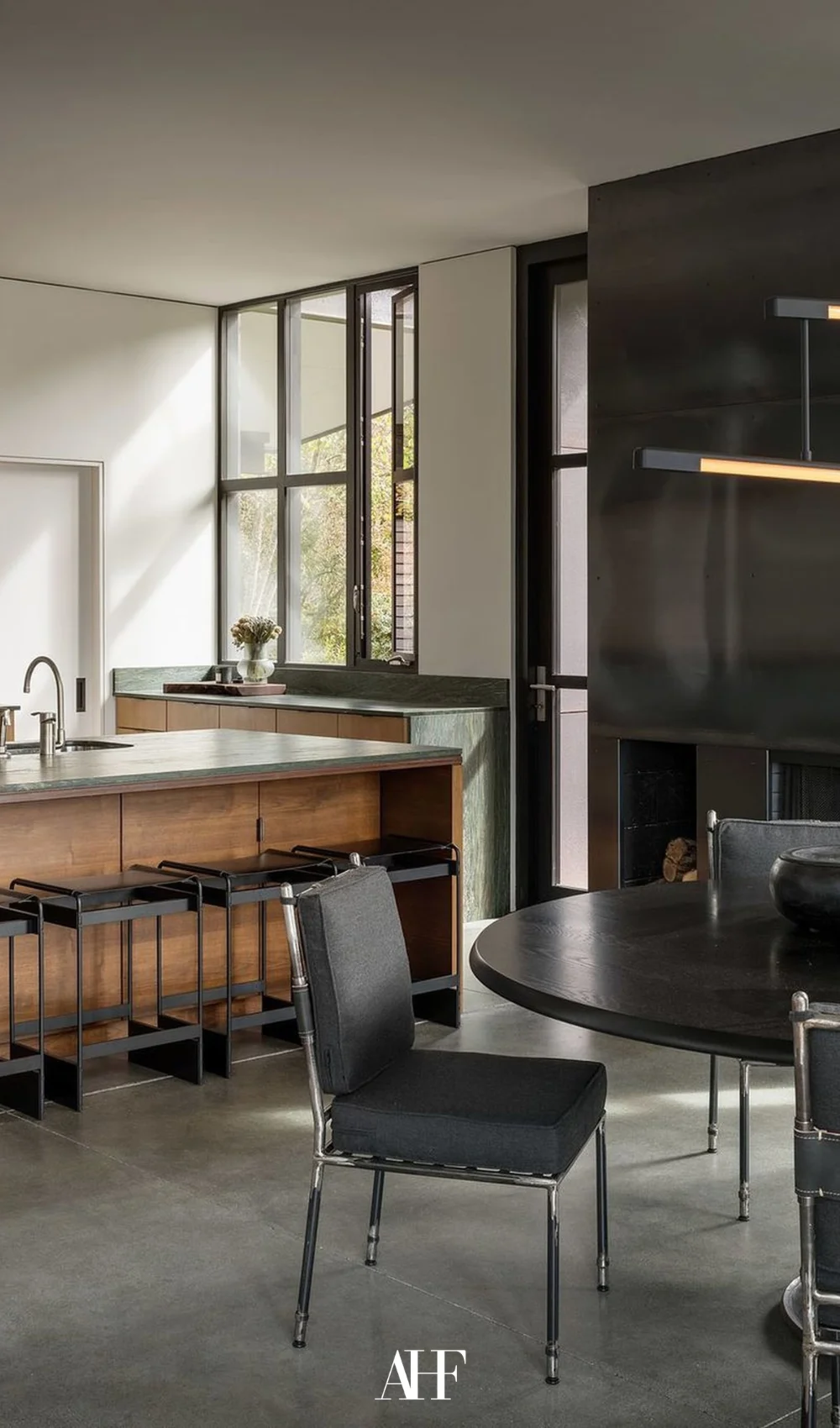 Industrial interior design kitchen with black table and wooden details on the kitchen island. A large window.