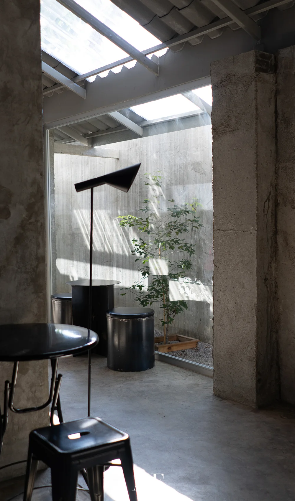An industrial chic with concrete walls and black details. Large windows.
