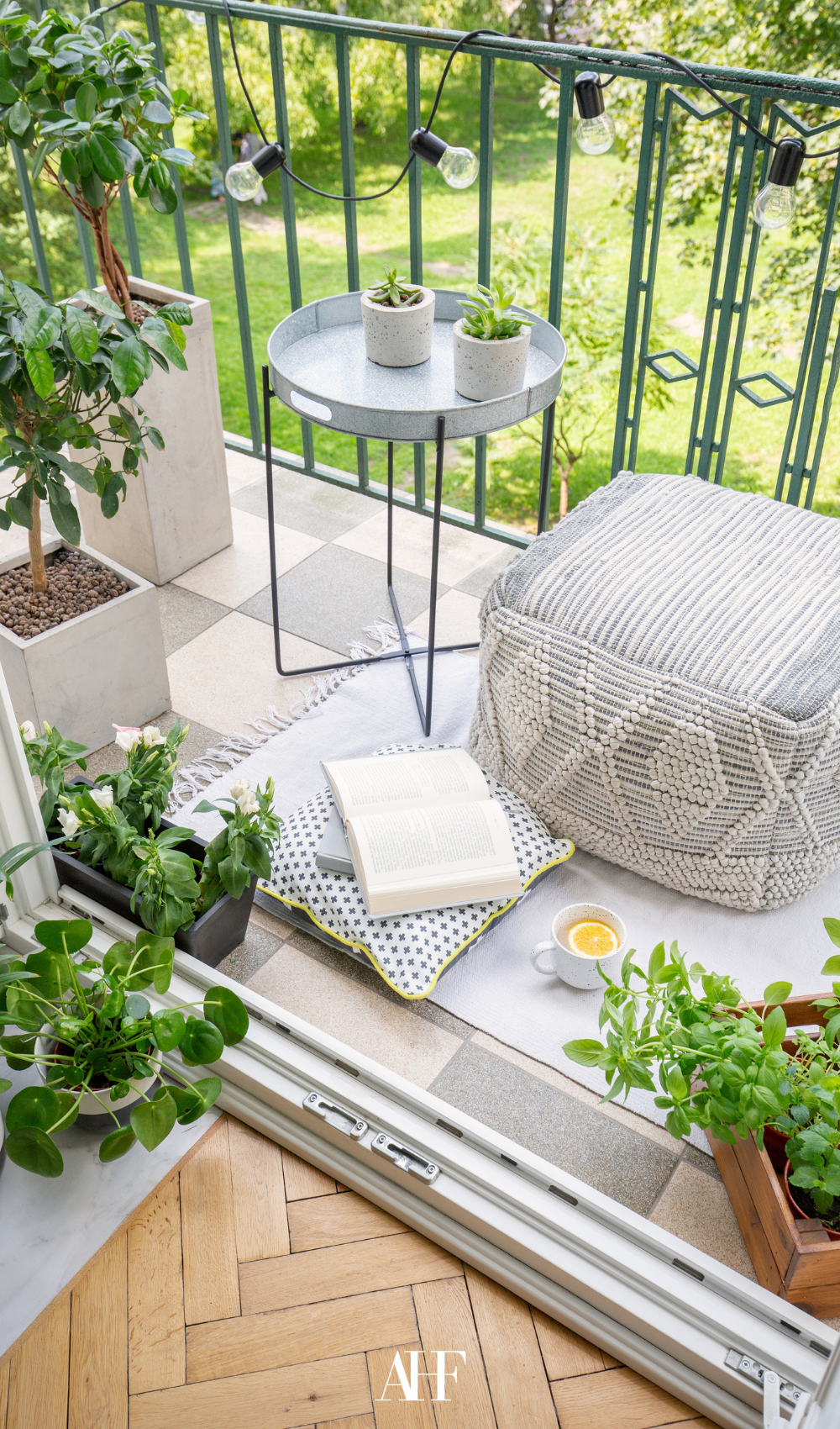 A very small summer patio with a little boho inspo. Lots of plants and a pouch and a table.