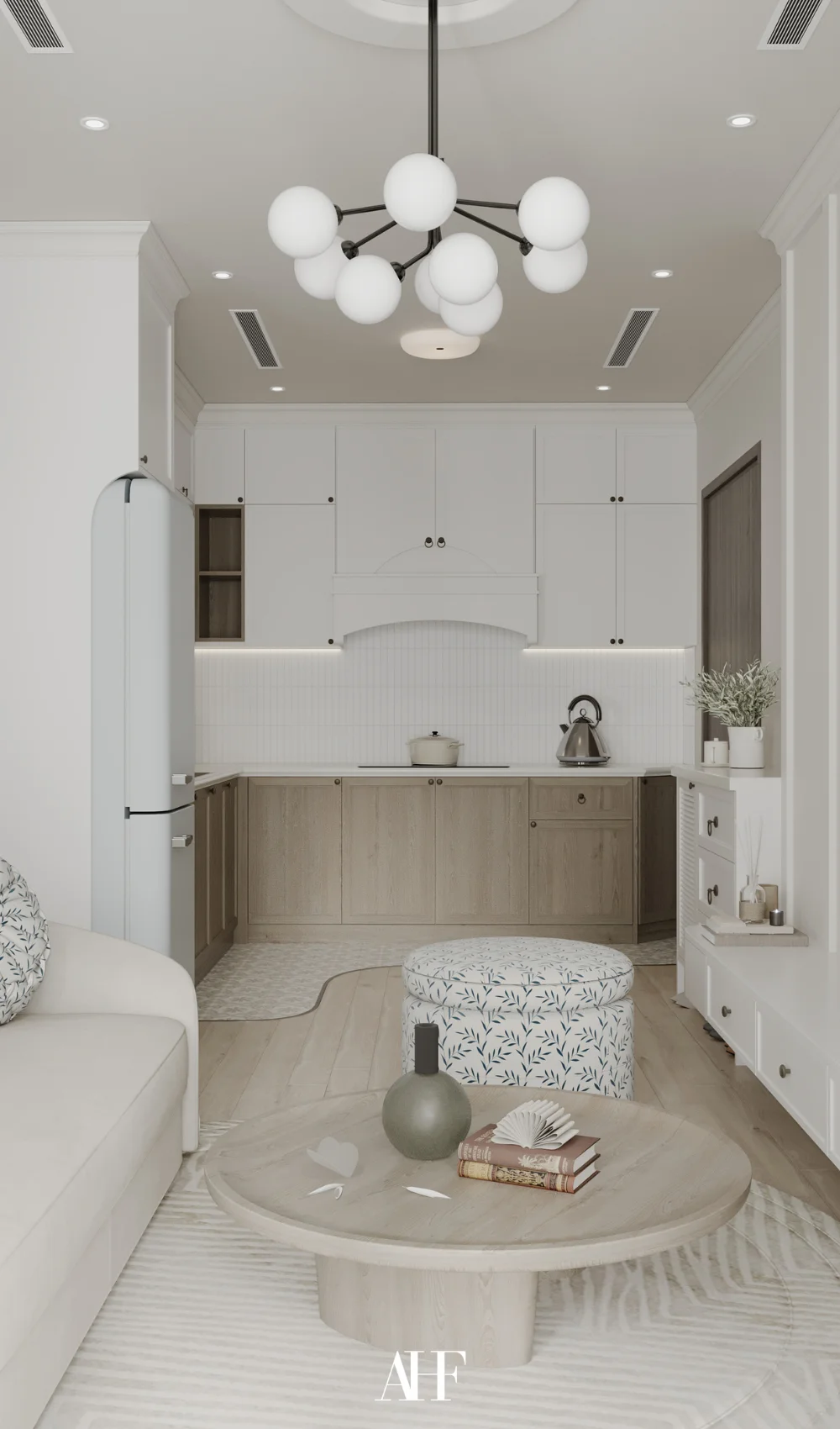 A small apartment living room with a white large sofa and a wooden kitchen in the distant.
