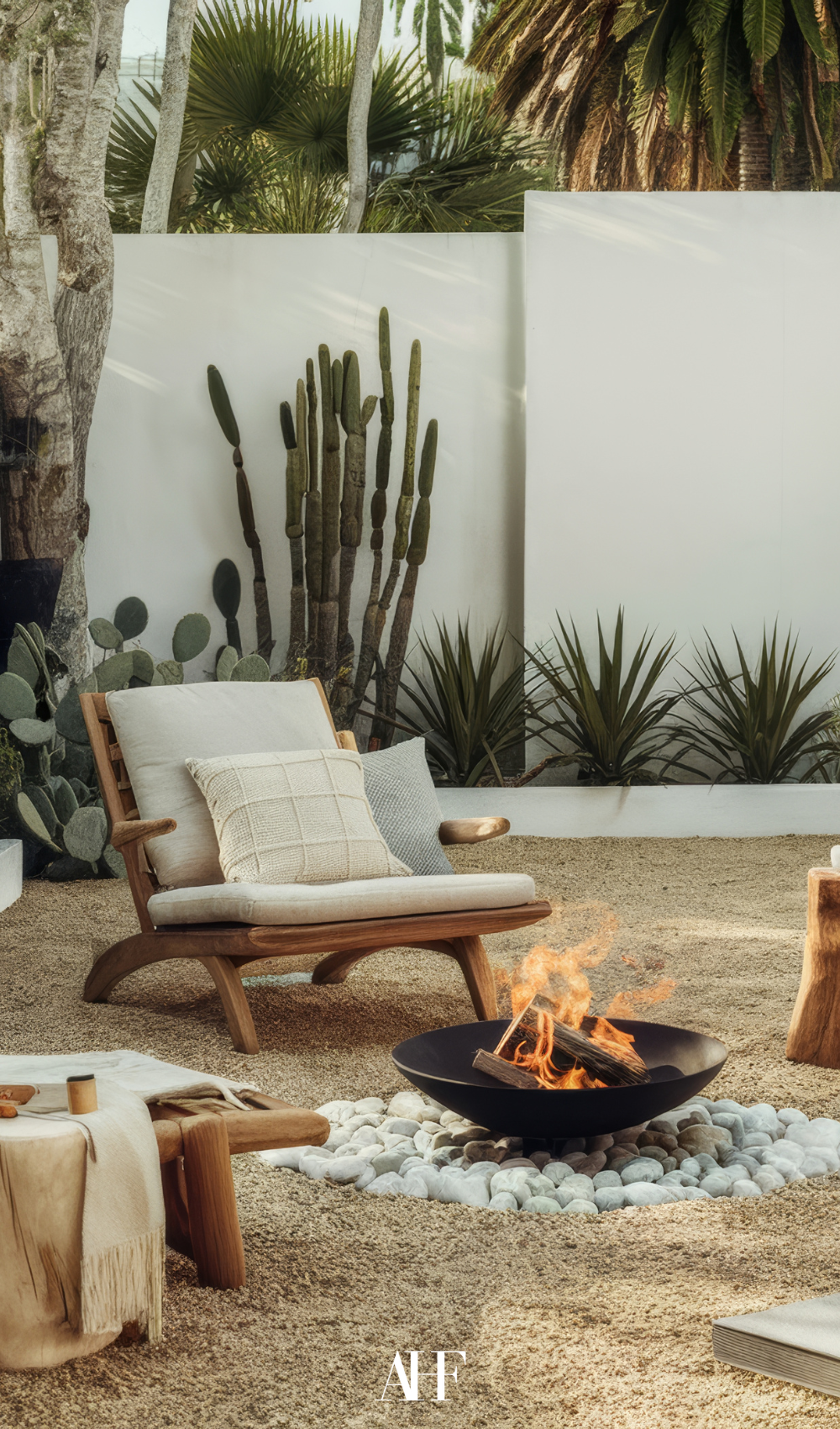 A cozy summer patio with a fire in the middle and wooden armchairs around it. Cactuses in the background.