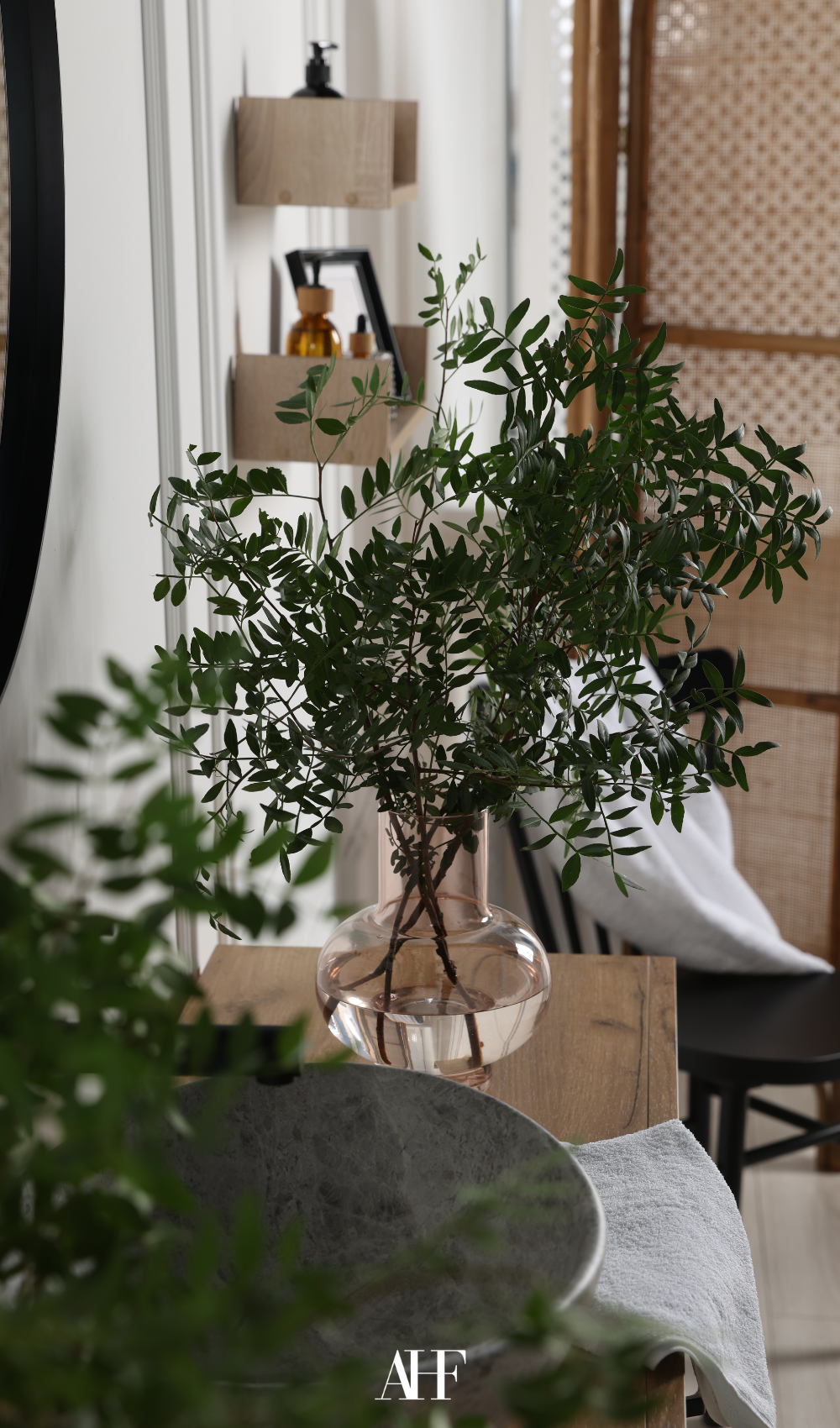 A closeup on a plant standing on a wooden side table.