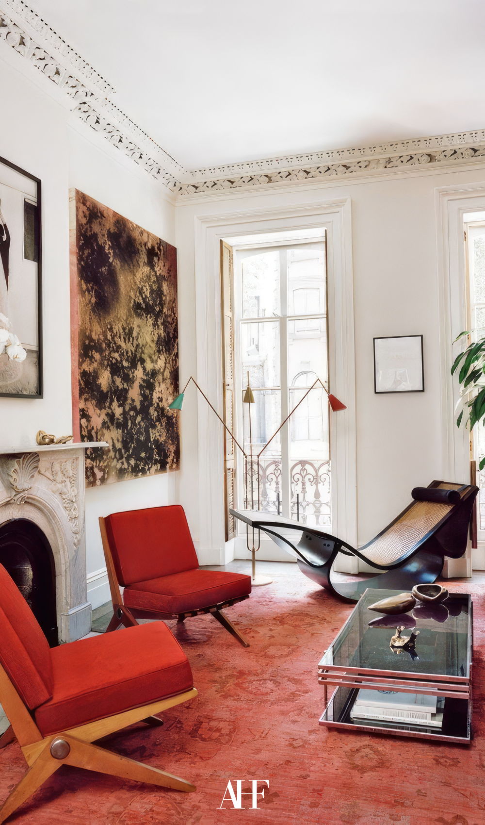 A maximalist interior design living room with red armchair and colorful and bold decor.
