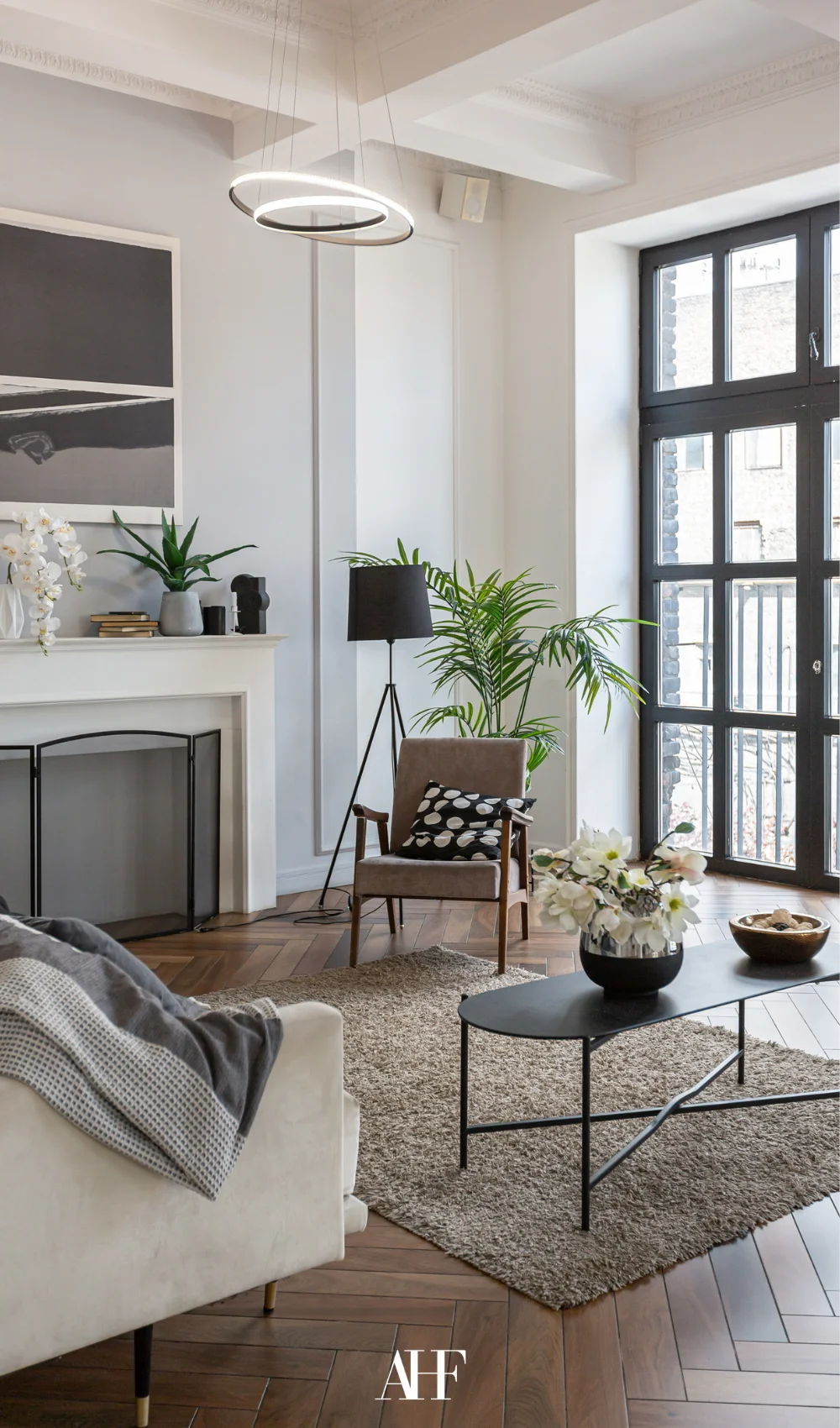 Small apartment living room with a large window, an armchair, a coffee table and some decorations.