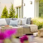 A beautiful summer patio with bright furniture and some plants.