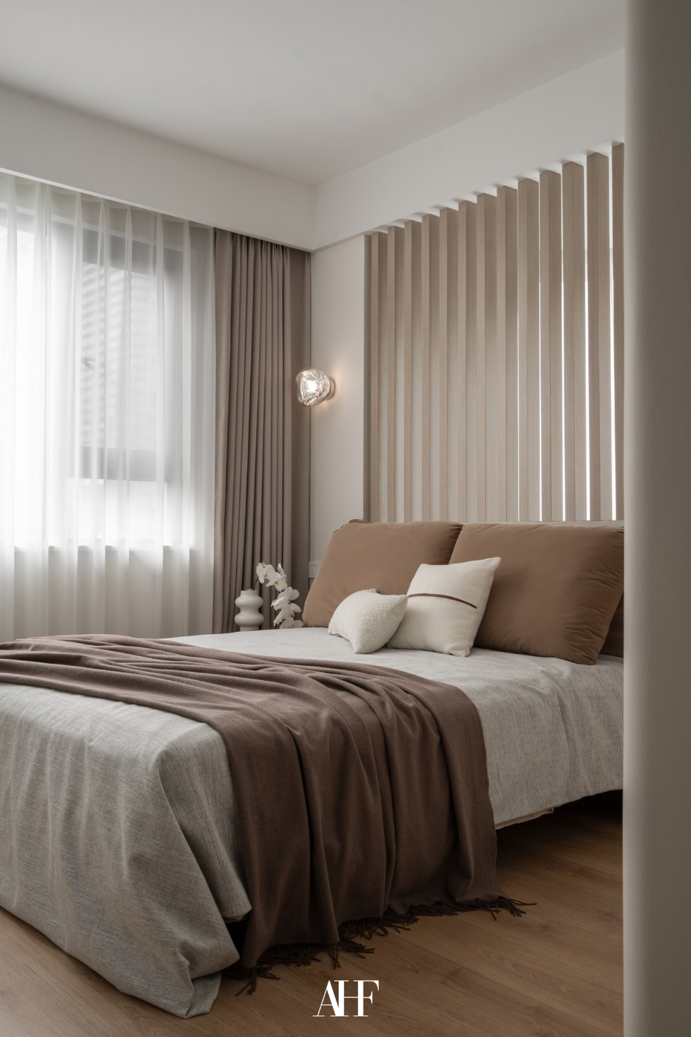 Neutral bedroom with white bedding and terracotta blanket and details. Lots of neutral decor pieces.