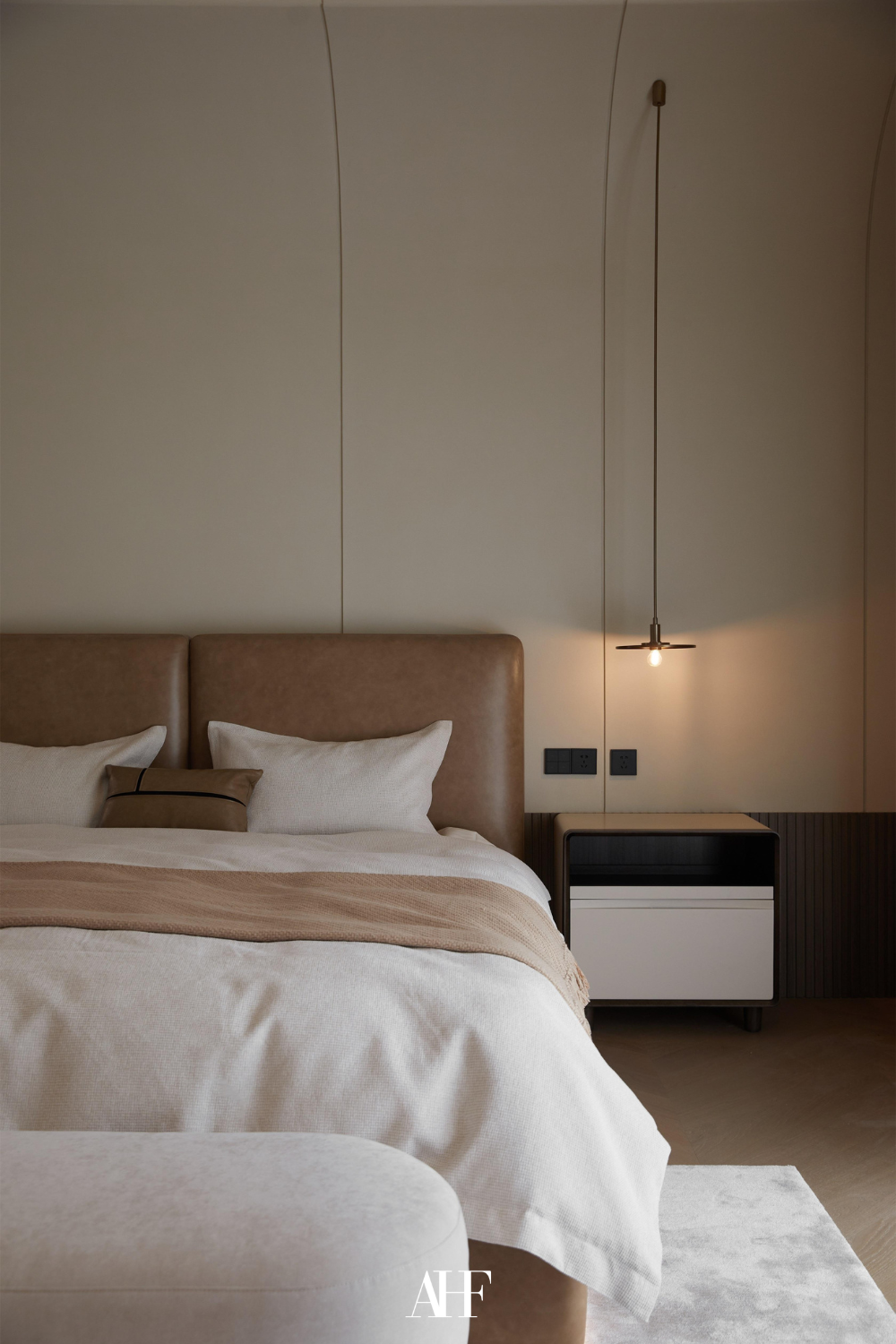 A warm and inviting bedroom color combinations. A leather bed frame and white bedding. Dark wooden details. 