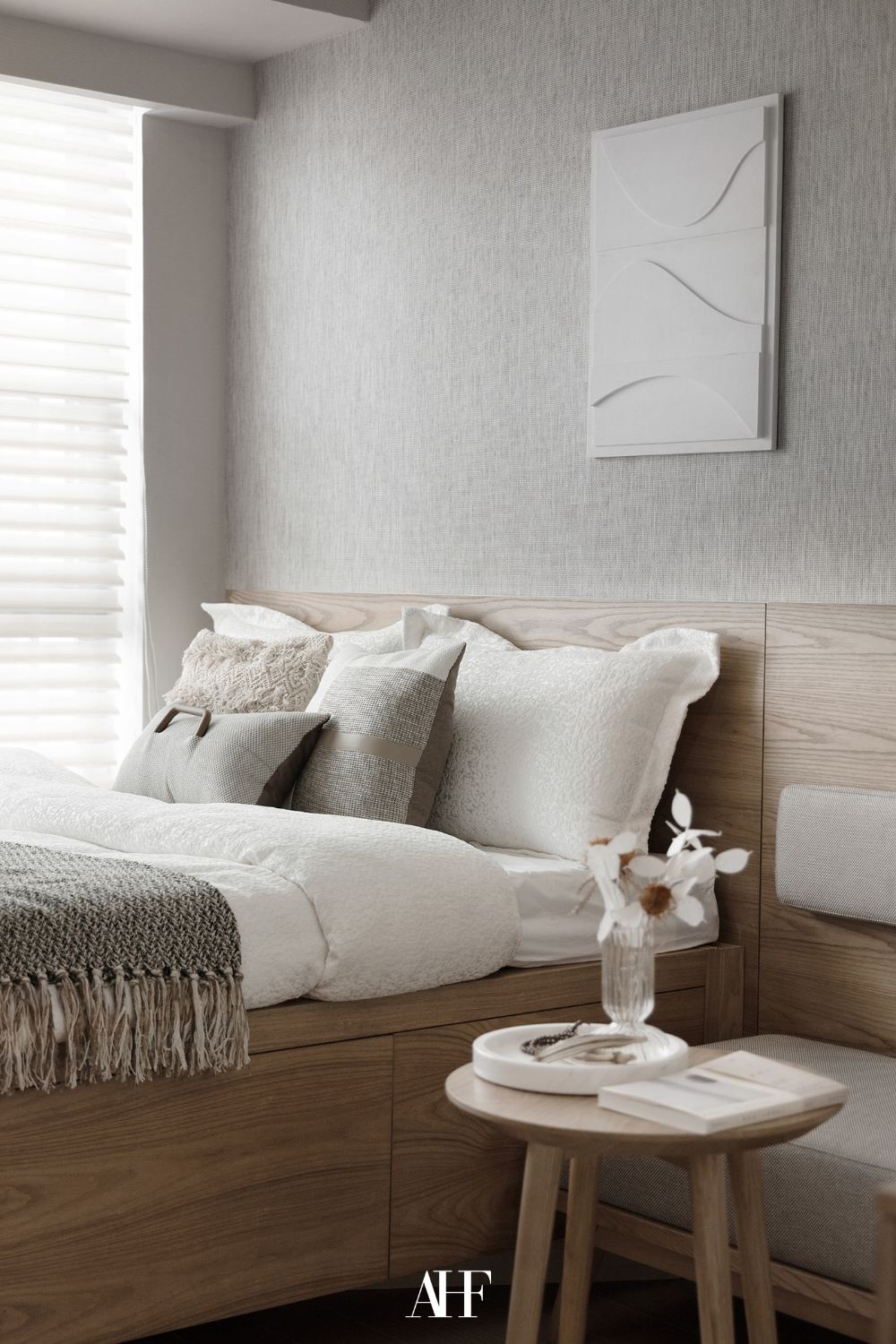 A bedroom color scheme with a light charcoal and light wooden colors. A bed with a light wooden bed frame and a neutral bedding with light charcoal blanket and pillows. 