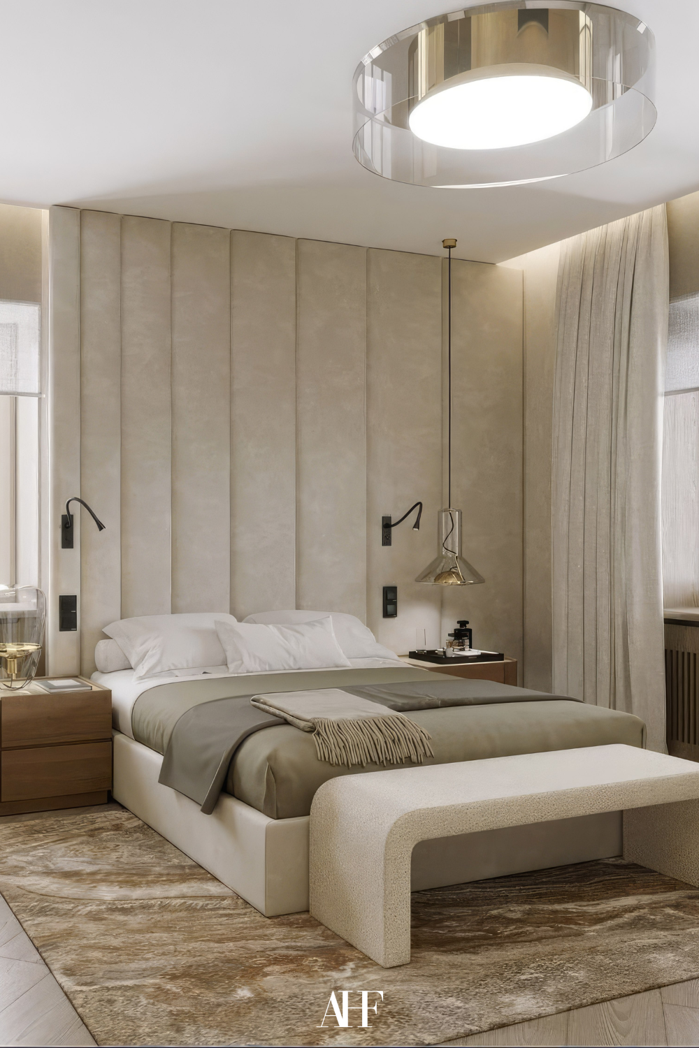A neutral bedroom with a large beige bed and a large rug. Darker beige bedding and a wooden bedside table. Large windows. 