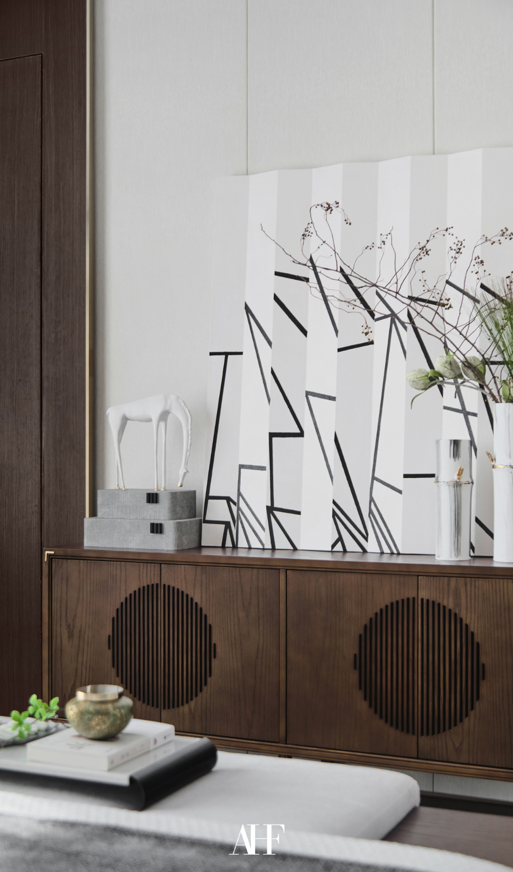 An aesthetically decorated living room with a wooden sideboard, a wall art and decorations. How to decorate your home.