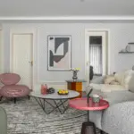 How to decorate your home, a colorful living room with a pink armchair and a light grey sofa. Colorful details and decorations.