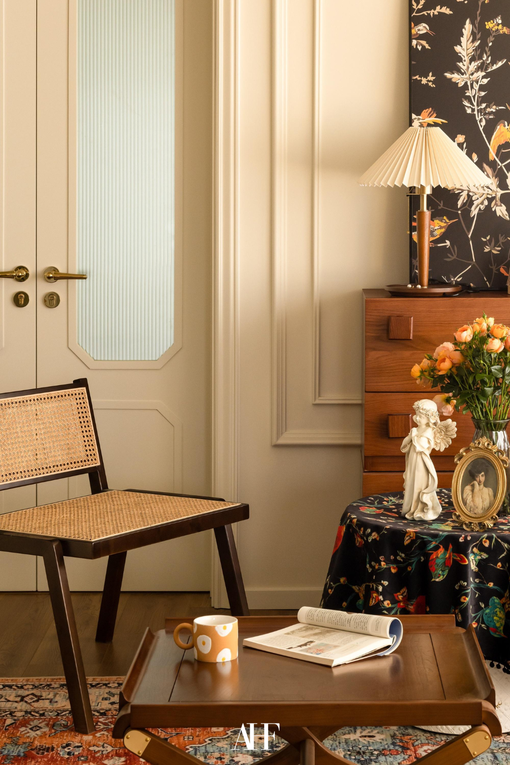 A vintage interior design inspired living room with a rattan armchair, a wooden dresser and a vintage minimalist interior design table lamp.