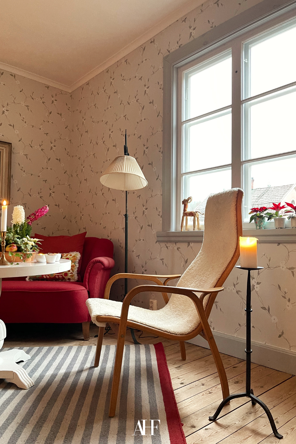 Cherry coded interior with a cherry red sofa and some farmhouse details. A wooden accent chair and large windows. Cherry coded home.  