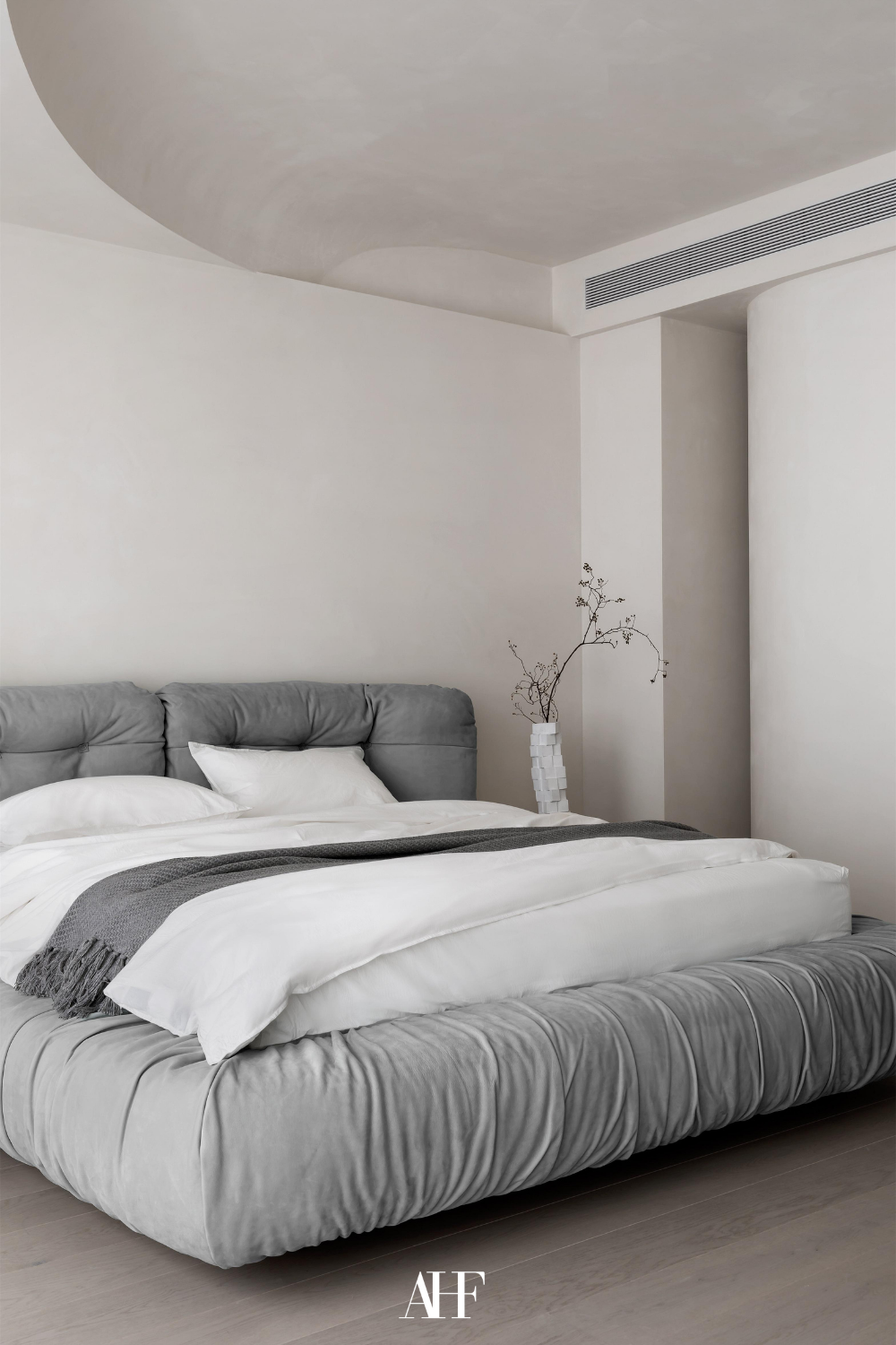 Beautiful Cozy Japandi bedroom with grey bed frame and white bedding. White walls and Japandi bedroom decor.