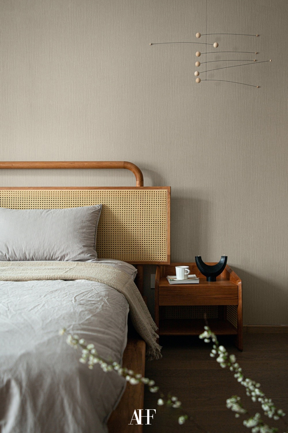 A wooden bed frame with a wooden bedside table. Neutral bedding. Japandi bedroom ideas.