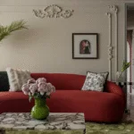 Cherry coded interior with a large cherry red sofa and a marble coffee table and a green rug. Beautiful interior, cherry coded home.