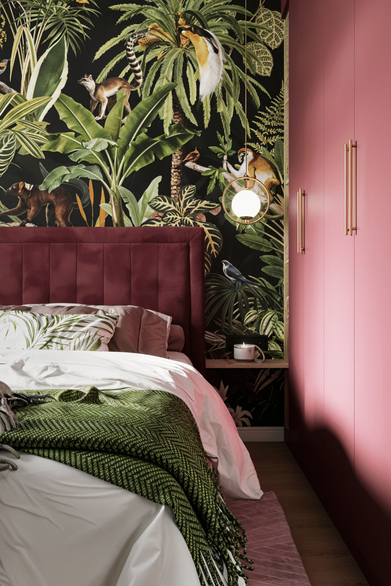 A colorful bedroom with a burgundy wall and a wall with green leaves. A colorful room.