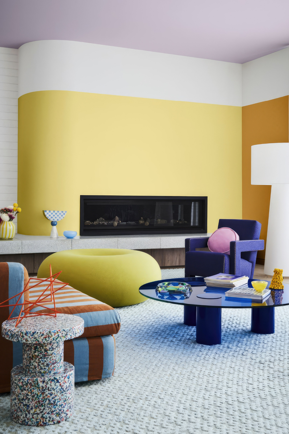 How to decorate with colors, a colorful home with a color palette inspiration. Yellow walls, a donut chair, and a striped sofa.
