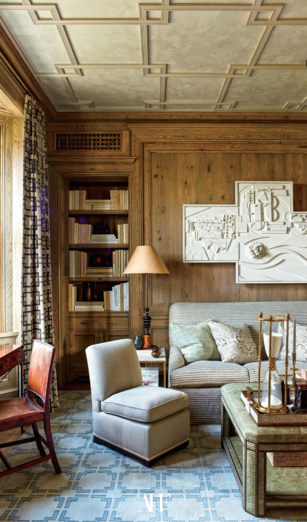 London townhouse with wooden walls, beige sofa and armchair, a wooden coffee table and lots of details.