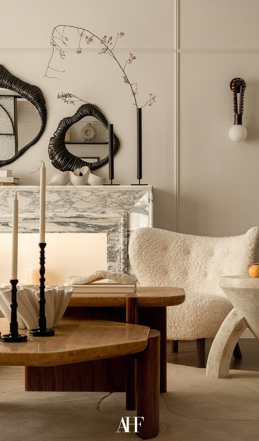 Interior design ideas. A cozy living room with a fluffy white teddy armchair, wooden coffee tables, marble mantle and decorations. 