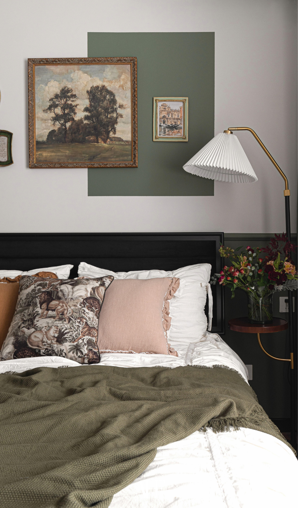 A beauitufl bedroom with lots of colors and a cozy bedside lamp. Frames on the wall and green details. Interior design ideas. 