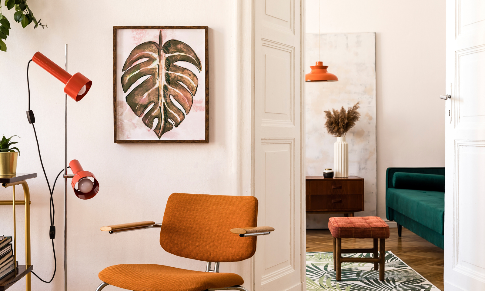 A mid century modern living room with an orange armchair, a teal sofa in the background. Interior design ideas.