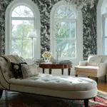 A London townhouse interior with a chaise longue and patterned walls. Large curved windows.