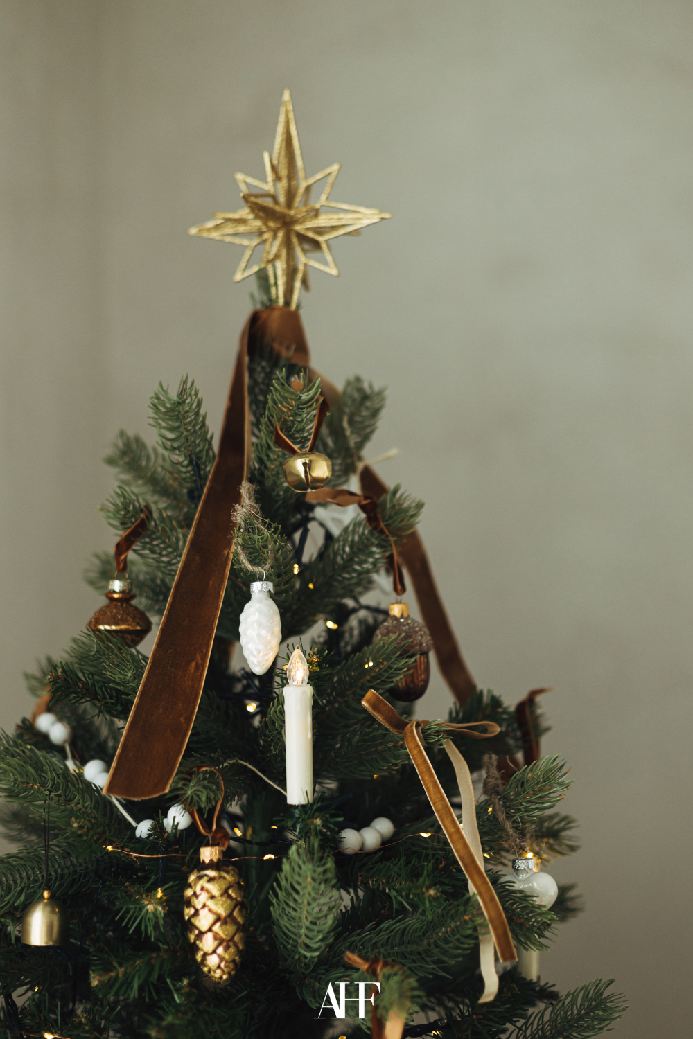 The top of a Ralph Lauren Christmas tree with a golden star at the top and brown velvet bows in the tree.