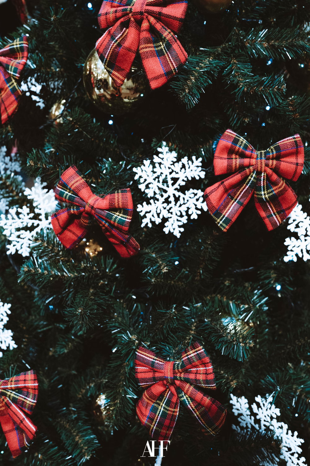 Tartan bow ralp lauren christmas tree and white snowflakes. Closeup.