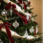 Closeup on a Ralph Lauren inspired Christmas tree. Red bows and glass ornaments.